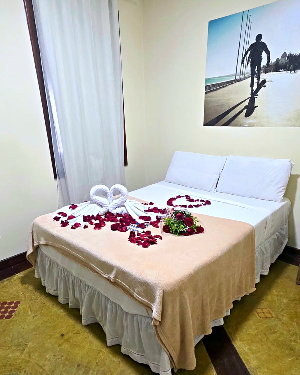 Suíte de casal decorada com pétalas e toalhas em forma de cisne